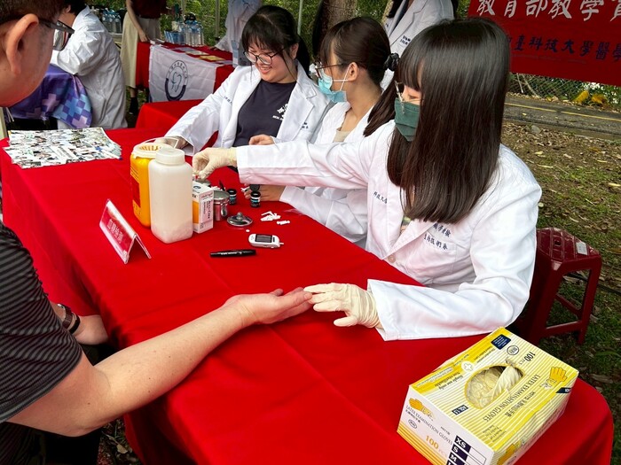 學生幫民眾測量血糖圖片